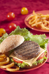 Beef Burger with bell pepper and lettuce with cherry red and yellow tomato on Red background 