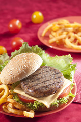 Beef Burger with bell pepper and lettuce with cherry red and yellow tomato on Red background 