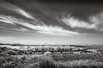 black and white landscape of Costa Esuri, Ayamonte urbanisation and the International bridge over the Guadiana River between Spain and Portugal
