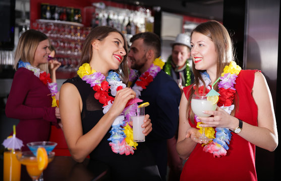 Female colleagues on company party in Hawaiian style in bar