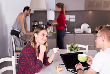 Girl talking to guy in kitchen of hostel