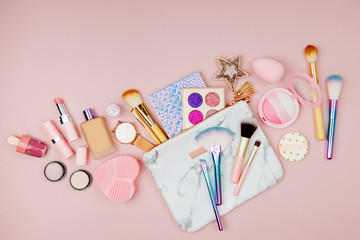 Female cosmetics collage with lipstick, brush and other accessories on pink background. Flat lay, top view.