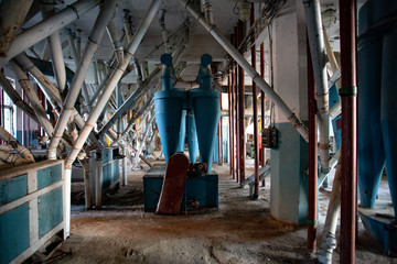 Abandoned flour milling factory. Old rusty pipeline and other equipment 