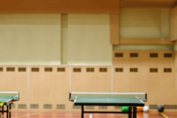 Naturally blurred interior of modern gym with tables for ping-pong