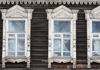 Carved wooden trim facade. Old historic house. Russian architecture. Chopped house with carved wooden architraves. Tomsk, Russia