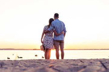 Couple walking on the beach at sunset