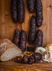 Still life of chorizo sausage garlic onion olive oil bread traditional kitchen isolated mediterranean spanish snack