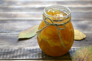 Apple jam in a jar on a wooden background