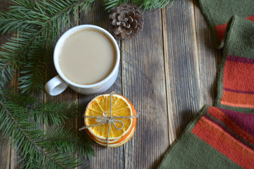 Cup of coffee with milk dried oranges and pine branches on a wooden background winter concept cozy home