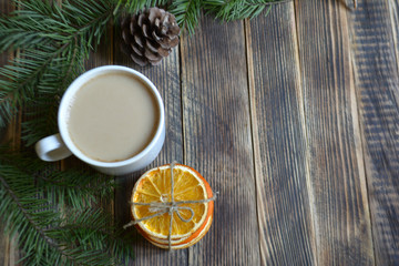 Cup of coffee with milk dried oranges and pine branches on a wooden background winter concept cozy home