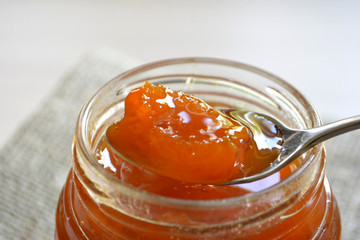 Peach apricot jam in a jar and spoon