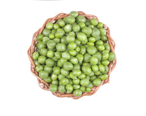 Green fresh peas in a wicker basket on a white isolated background