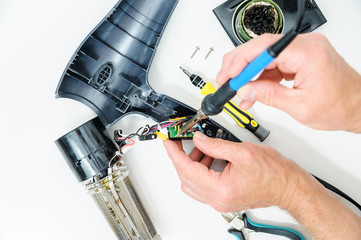 The man is repairing the hairdryer.