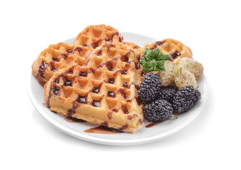 Delicious sweet Belgian waffles in the form of hearts with chocolate and berries on a white isolated background.