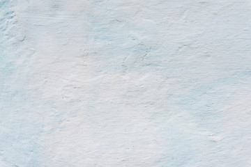 Adobe wall whitewashed by lime, white and blue color, textured background in retro style, closeup