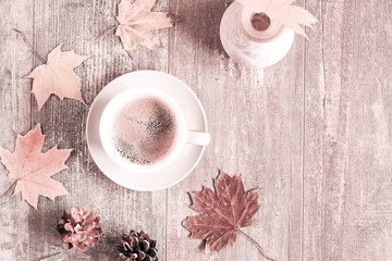 Autumn composition. Cup of coffee, autumn dry leaves and roses, cones on light pastel beige background. Autumn, fall, concept. Flat lay, top view, copy space 