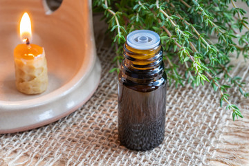 A bottle of thyme essential oil with fresh thyme