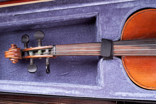 Old violin in opened case. String musical instrument in velvet case. Classic musical instrument.