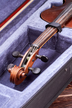 Velvet case with old viola instrument. Cello in box. Cello close up of scroll and peg box. Stringed instrument of orchestra.
