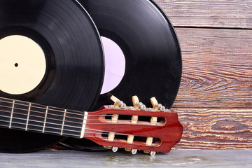 Set of vintage musical instruments. Two vinyl records and acoustic guitar fretboard on wooden...