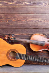 Guitar, violin and copy space. Acoustic guitar and violin on textured wooden background. Instruments for musician. © DenisProduction.com