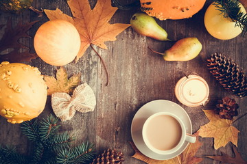 Autumn composition. Thanksgiving day concept. Cup of coffee, pear, candle, pumpkins, red and yellow leaves on dark wooden vintage background. Autumn, fall, background. Flat lay, top view, copy space 