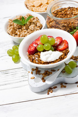delicious healthy breakfast with fruits, granola on white background, vertical top view