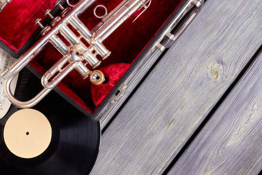 Vintage style musical objects. Trumpet, vinyl disc and musical notes on wooden boards with text space.