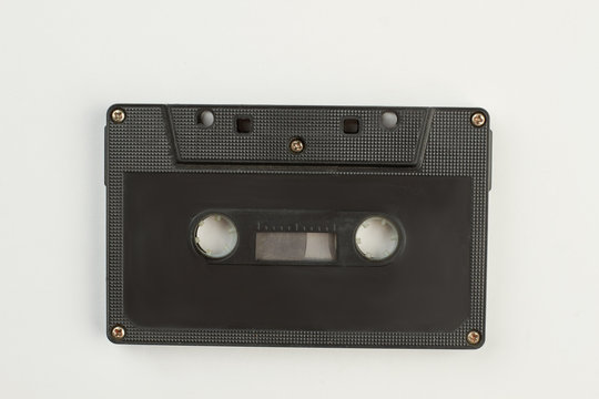 Black compact cassette on white background. Old cassette tape isolated on white. Reto musical technology.