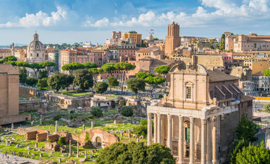 Fototapeta na wymiar Scenic sight in the Roman Forum, with the Temple of Antonino and Faustina, the Tower of the Militia and the Trajan's Market. Rome, Italy.
