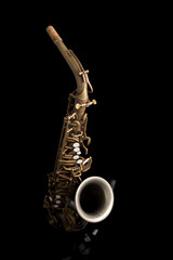 A matte finish saxophone on a black background