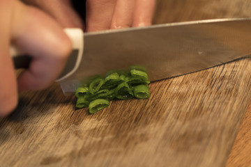 Spring onions being cut on a cutting board