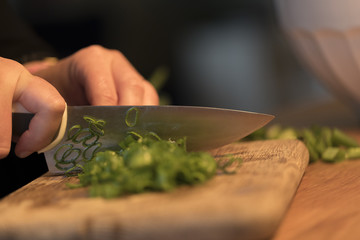 Spring onions being cut on a cutting board