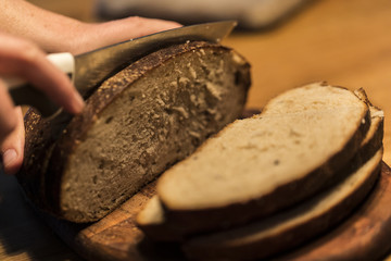 A person cutting a bread on a cutting board