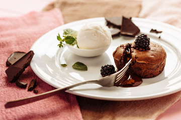 chocolate Fondan with syrup and ice-cream on a plate decorated with mint leaves