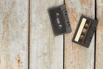 Used audio cassettes on old wooden floor. Two vintage cassette tapes on wooden planks and copy...
