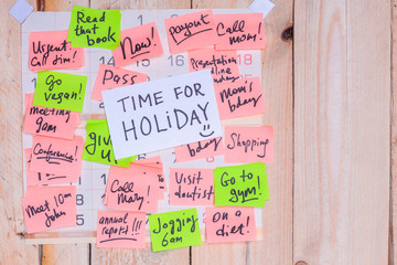 Time For Holiday written on sticky note pinned on pinboard