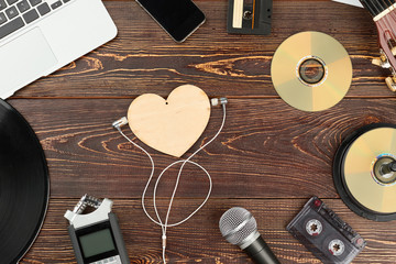 Wooden background with outdated and modern musical technology. Work space of composer or musician. Music recording scene.