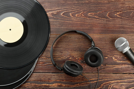 Headphones, vinyl records and microphone. Vinyl plates, headphones and microphone. Old and modern audio equipment.
