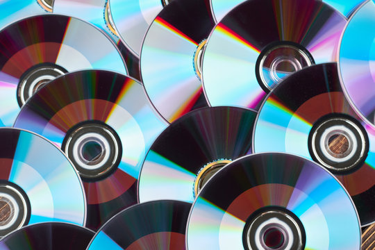 Close up group of DVD discs. Colorful compact disks background. Shiny CD disks as wallpaper.