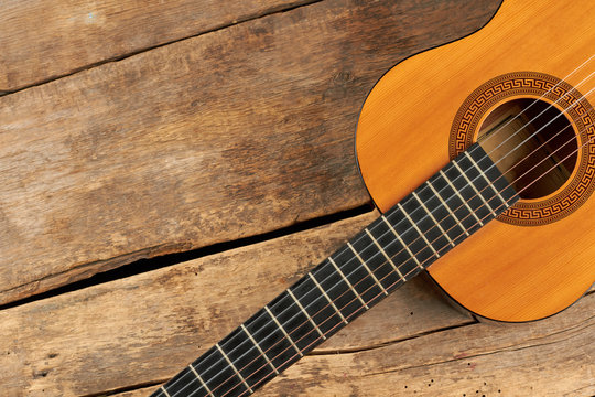 Guitar on wooden planks and copy space. Acoustic guitar on old wooden floor.