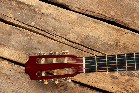Guitar fretboard with strings. Part of classical guitar on old wooden boards.