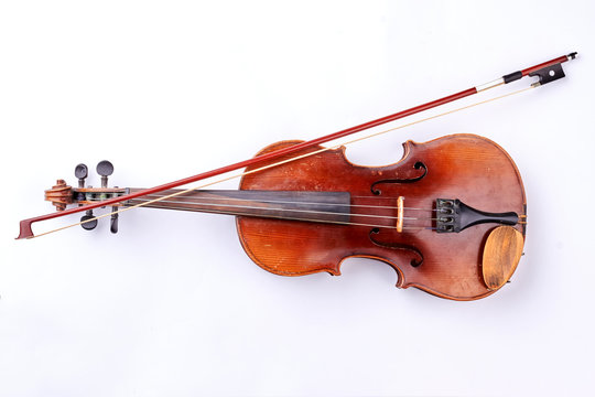 Vintage violin over white background. Retro style violin and fiddle stick. Instrument for orchestra.