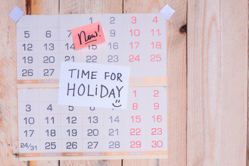 Time For Holiday written on paper note on a wall calendar with wooden background and copy space