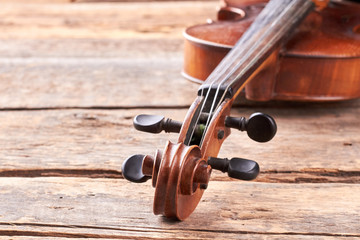 Close up violin on old wooden surface. Detail of musical instrument viola. Cello close up of scroll...