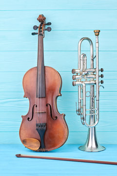 Trumpet and violin on colored background. Vintage trumpet, violin and fiddle stick. Objects of classical music.