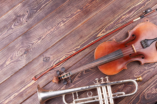 Old trumpet, violin and fiddle stick. Classical musical instruments and copy space. Retro style musical equipment.