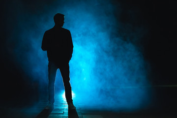 The man standing in the blue fog. evening night time