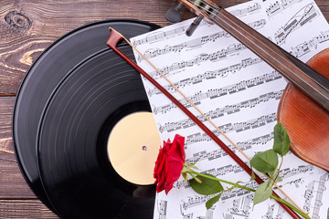 Musical background with classical vintage equipment. Vinyl records, musical notes, violin, bow and...