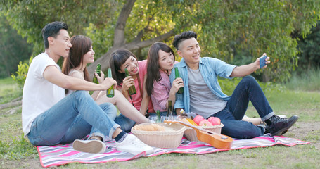 Friends go picnic together in the park and enjoy the food and drink